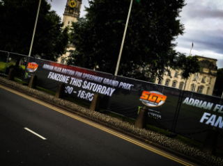 A printed Heras Fence Cover with a black background artwork used on a long stretch of balustrade